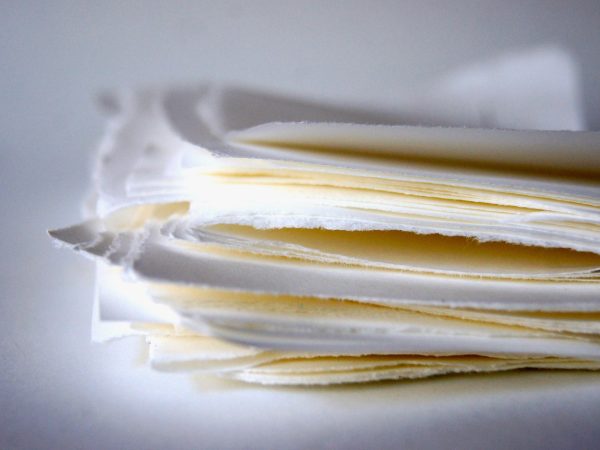 键盘与便签纸上的手写要点，用于记录蜜桃传媒与蜜月传媒差异化定位的判断标准